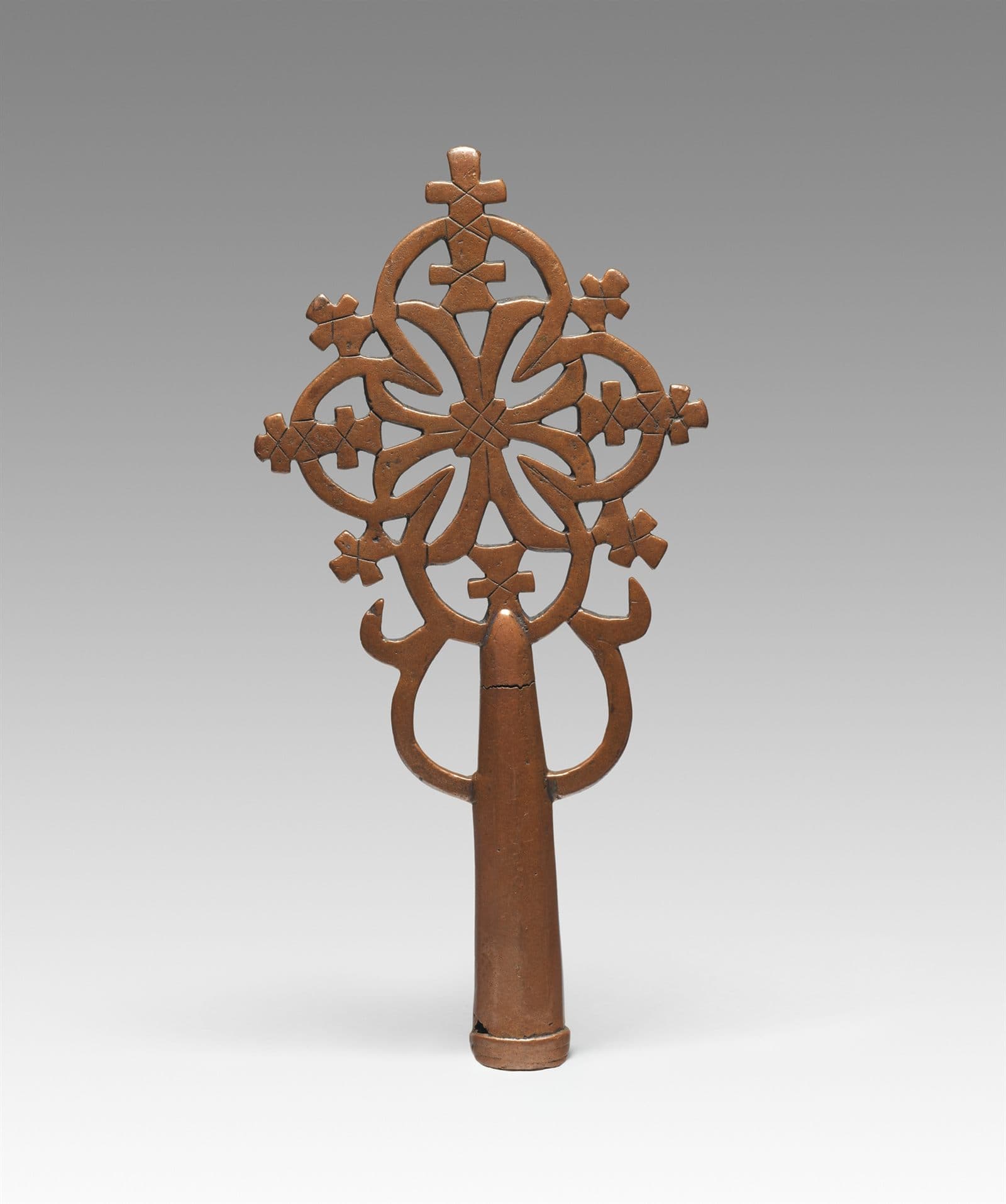 Ethiopian processional cross in cast metal, its arms formed from interlaced openwork tracery.