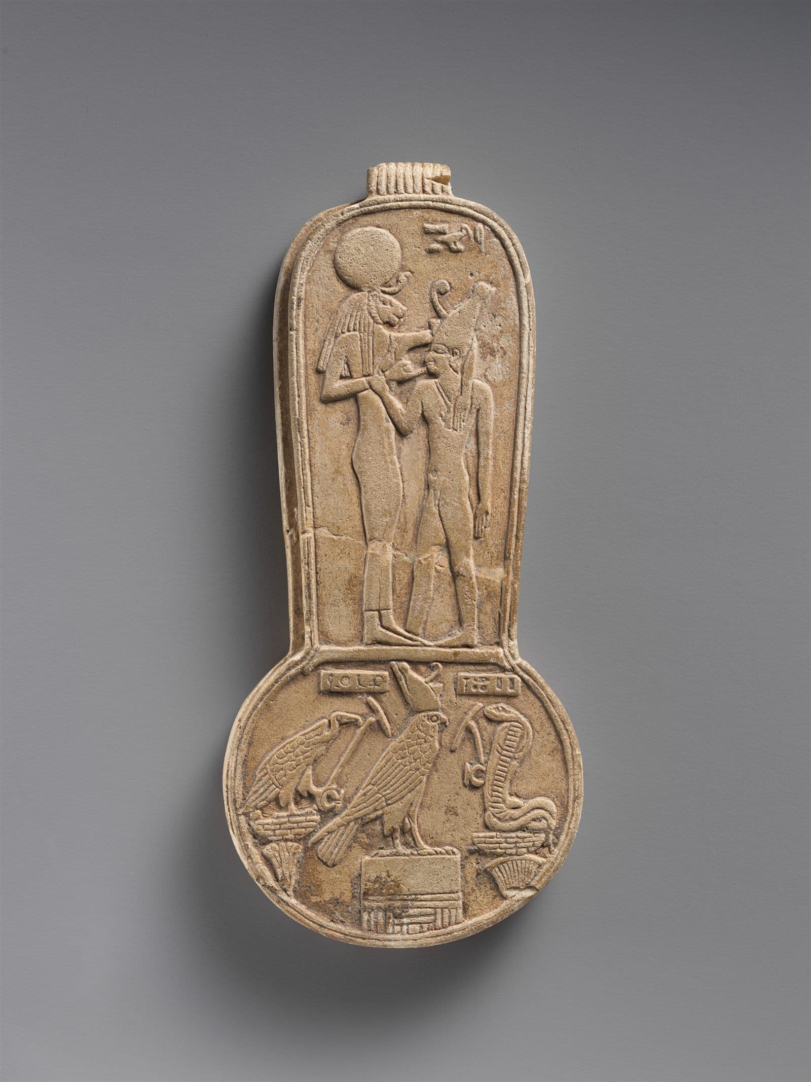 Bronze counterweight from a menit necklace showing the goddess Bastet nursing King Taharqo.